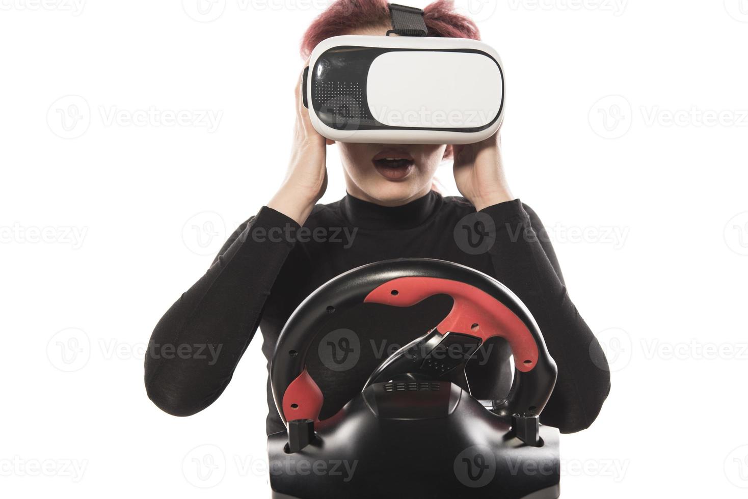 heureuse jeune femme à l'aide d'un casque vr et conduite isolé sur fond blanc photo