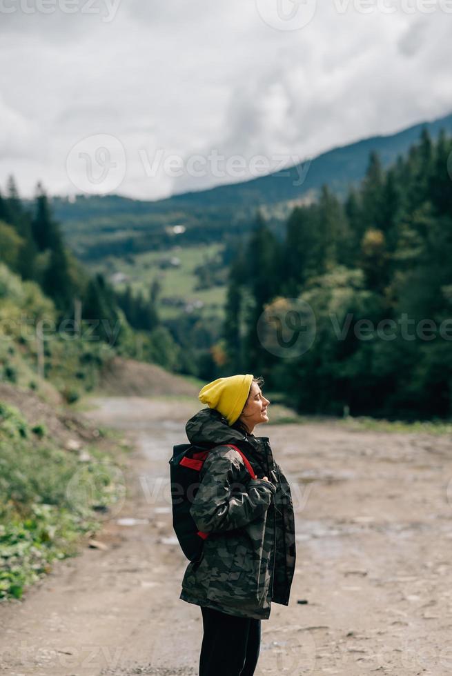 modèle hipster féminin actif et sain randonnée le long de la route de montagne forestière. photo