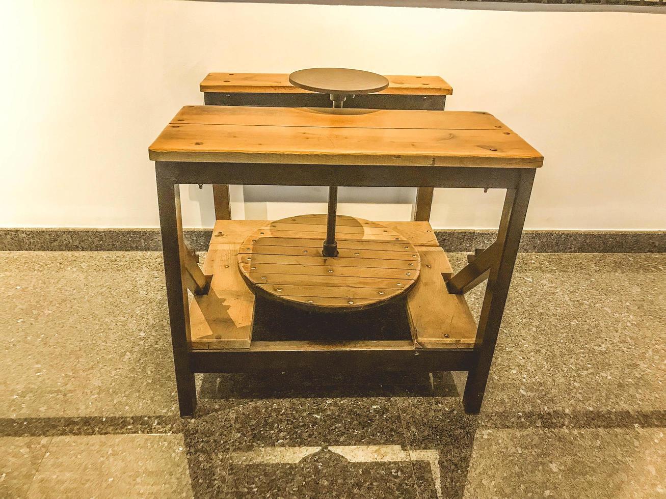 pièce de musée. ancien métier à tisser en bois naturel. cercle pour enrouler les fils et le tissu. table et siège pour une personne travaillant avec ses mains photo