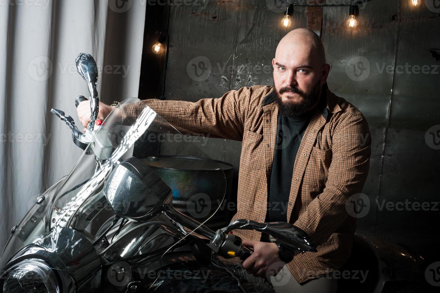 portrait d'un homme en chemise avec une barbe sur une moto photo