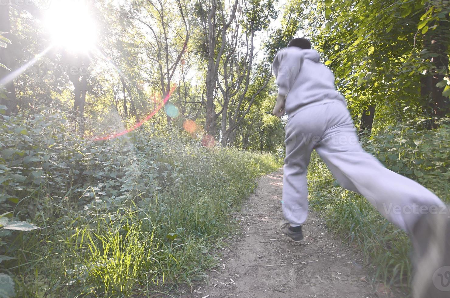 un jeune homme en costume de sport gris court le long du chemin parmi les photo