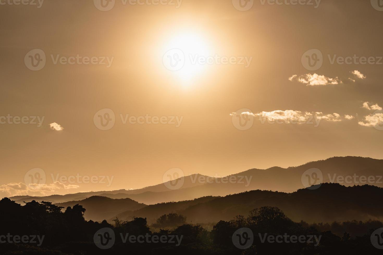 paysage de coucher de soleil avec éclairage doré de montagne et de soleil sous un ciel de soirée coloré et vibrant dans les montagnes. nature montagne ciel et nuages coucher de soleil concept photo