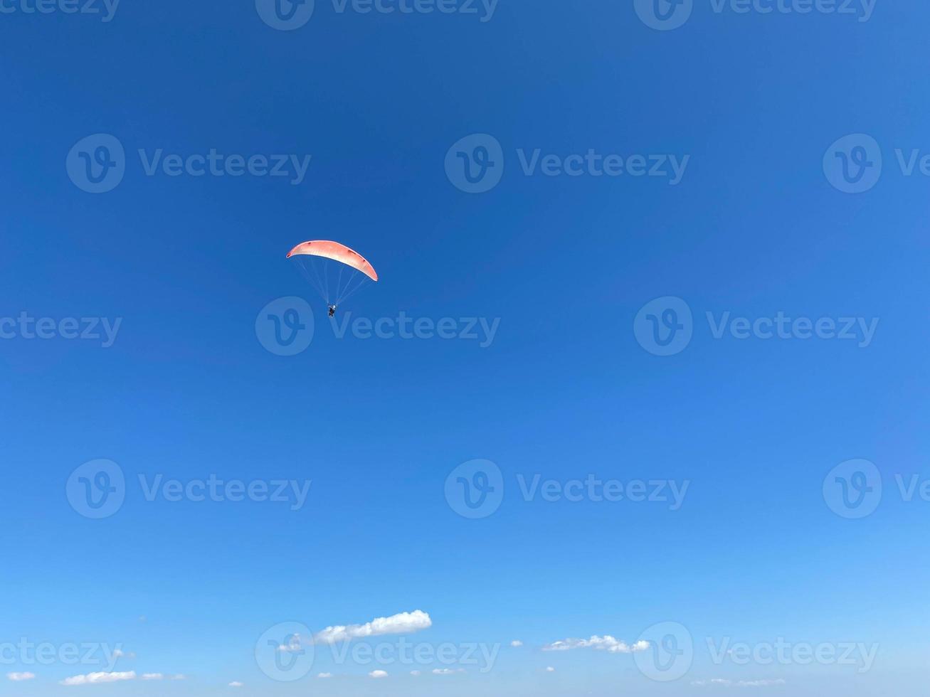 jeune homme parapente pendant l'été au large des falaises de baja, mexique photo