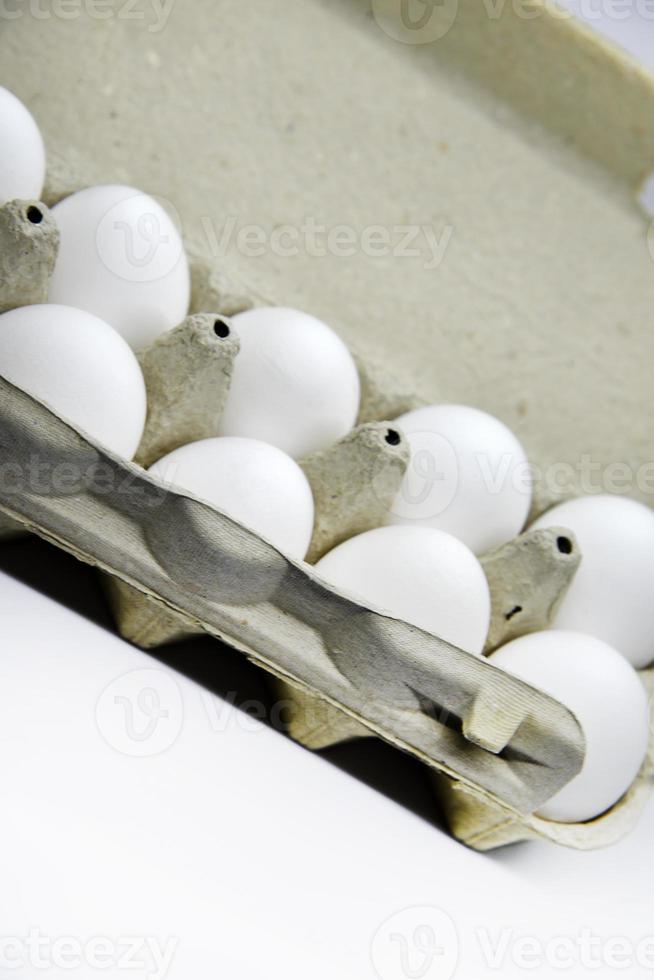 oeufs de poule blancs frais dans un sac en papier. oeufs blancs dans un emballage sur fond blanc. oeufs du magasin. photo