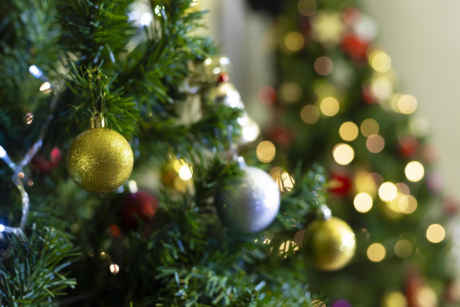 boule olden accrochée à la branche d'arbre de noël avec fond doré bokeh pour carte de célébration et design avec espace de copie photo