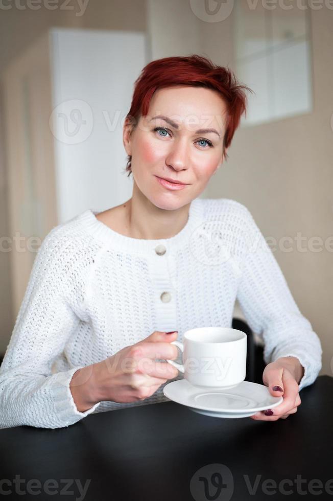 femme buvant du café le matin, à table photo