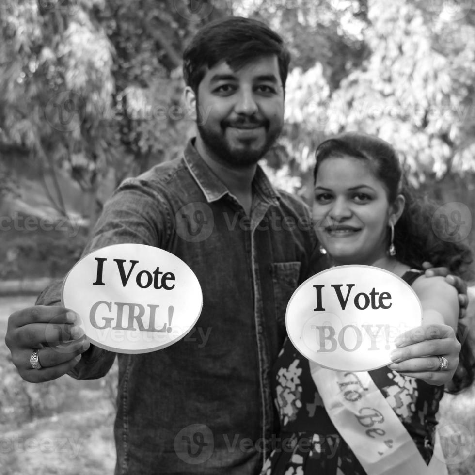 couple indien posant pour une séance photo de maternité. le couple pose dans une pelouse avec de l'herbe verte et la femme étale sa bosse de bébé dans le jardin de lodhi à new delhi, inde