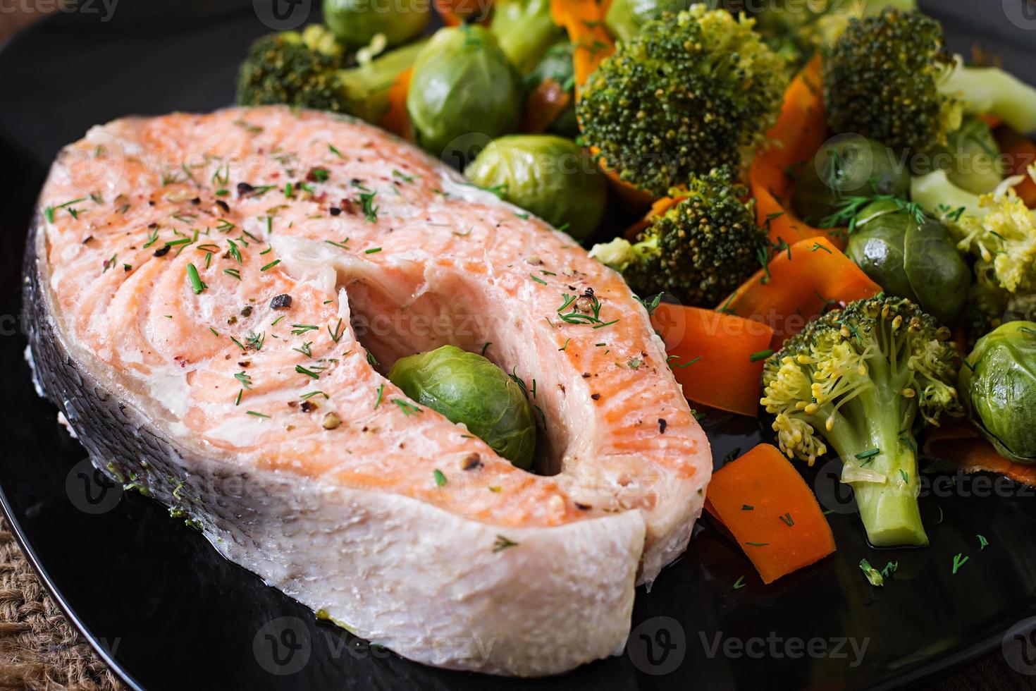 cuit sur pavé de saumon vapeur avec légumes. photo