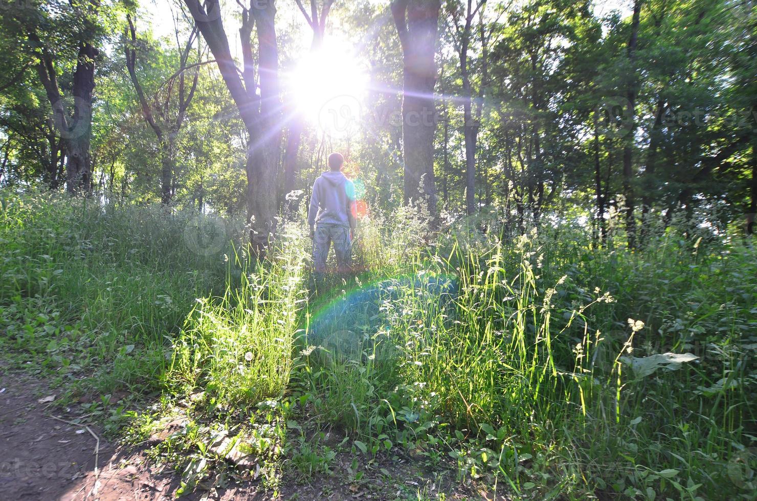 un jeune homme en costume de sport gris se tient en face du soleil parmi photo