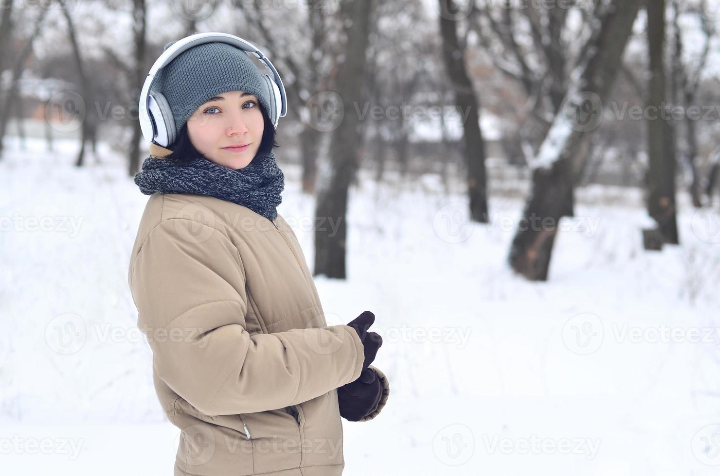 portrait d'hiver de jeune fille avec des écouteurs photo