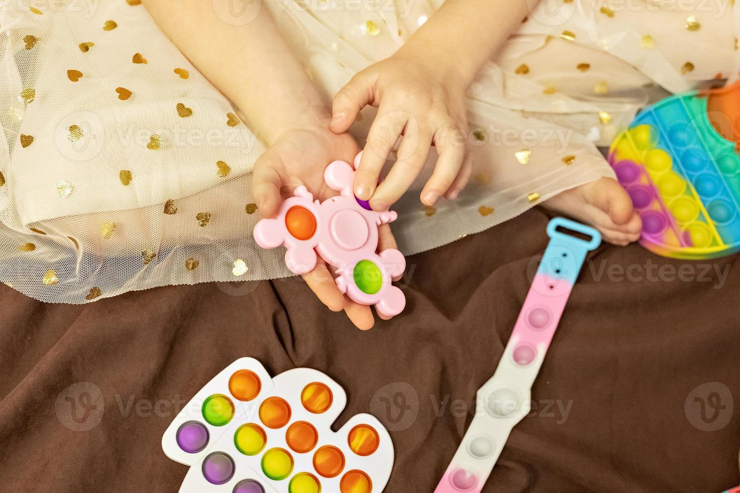 pop it est un jouet anti-stress multicolore entre les mains des enfants.  jeu de bulles. jouets anti-stress. 15601550 Photo de stock chez Vecteezy