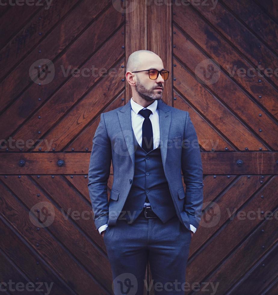 homme à la mode contre un mur en bois photo