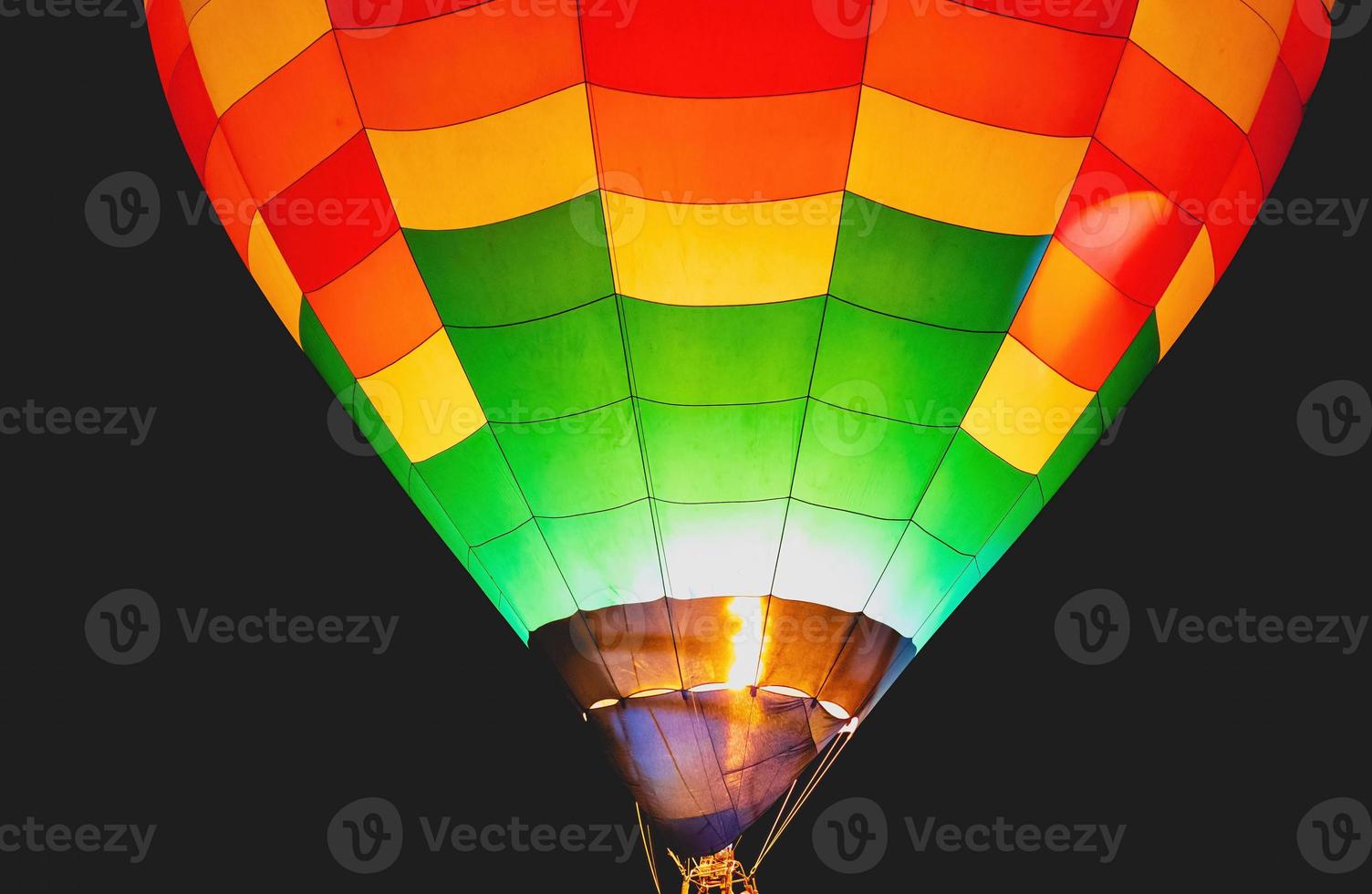 gros plan de beaux et brillants ballons rouges, bleus, jaunes et oranges s'élevant dans le ciel nocturne avec un fond noir. photo