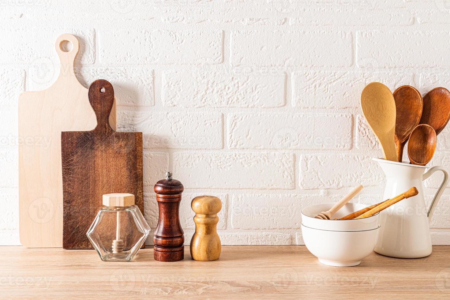 fond de cuisine moderne de cuisine écologiquement propre. un ensemble d'ustensiles de cuisine sur un comptoir en bois contre un mur de briques blanches. photo