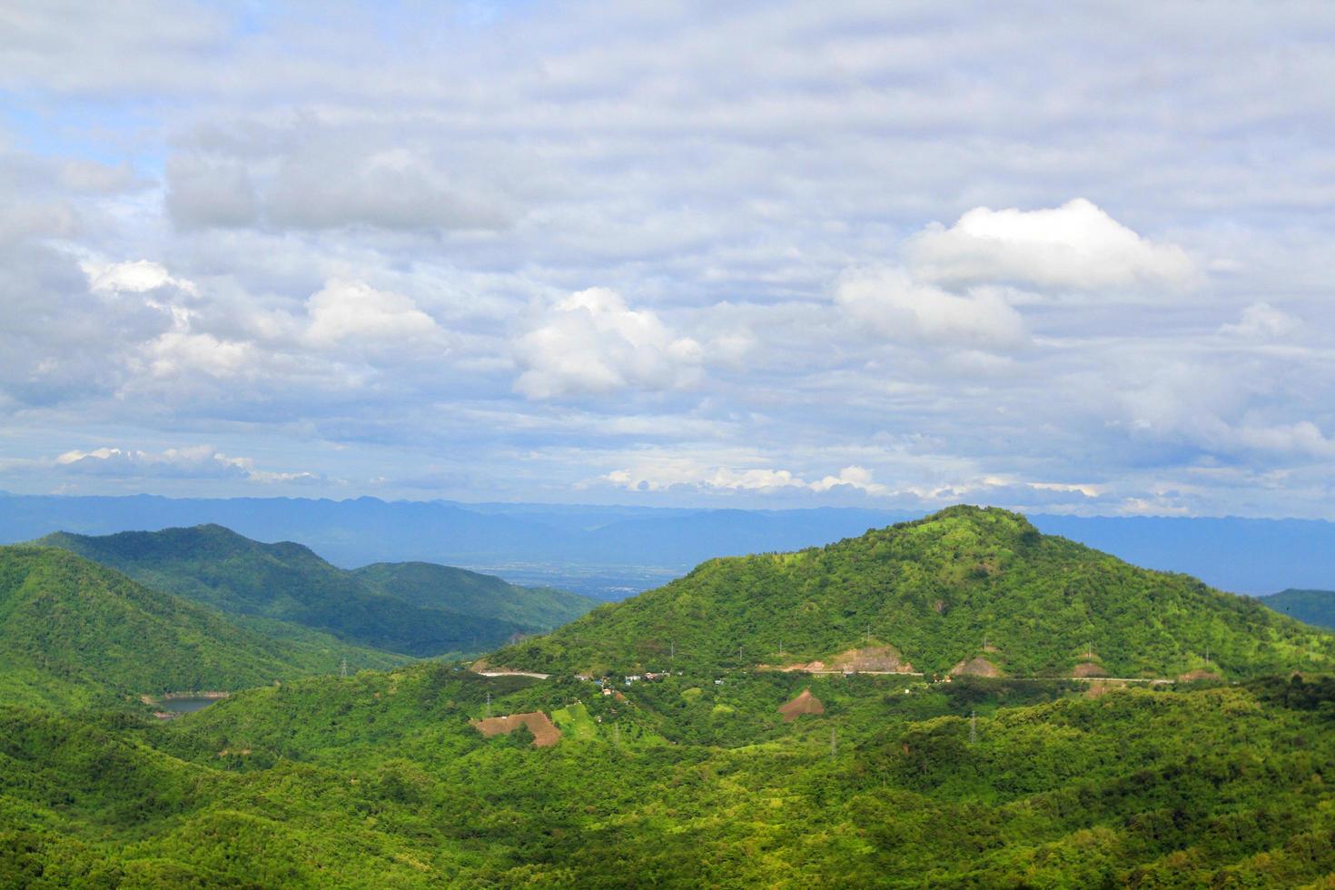 belle vue sur le paysage de la montagne, du petit village et de la route ou de la rue pour voyager avec un ciel bleu et des nuages au nord de la thaïlande. beauté dans la nature et vivre avec le naturel. photo