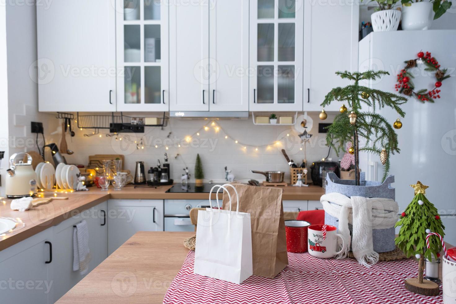 conteneurs de service de livraison de nourriture sur table blanc scandi cuisine festive dans un décor de noël. réveillon du nouvel an, gain de temps, trop paresseux pour cuisiner, commande chaude, boîte en plastique jetable en guirlande lumineuse. maquette photo