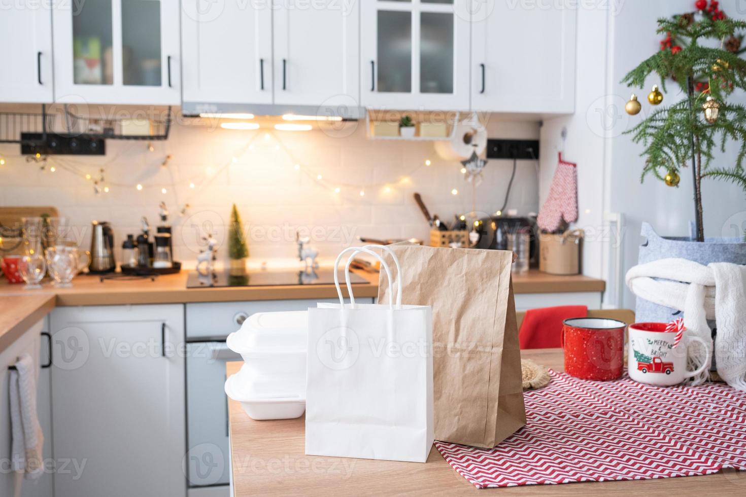 conteneurs de service de livraison de nourriture sur table blanc scandi cuisine festive dans un décor de noël. réveillon du nouvel an, gain de temps, trop paresseux pour cuisiner, commande chaude, boîte en plastique jetable en guirlande lumineuse. maquette photo