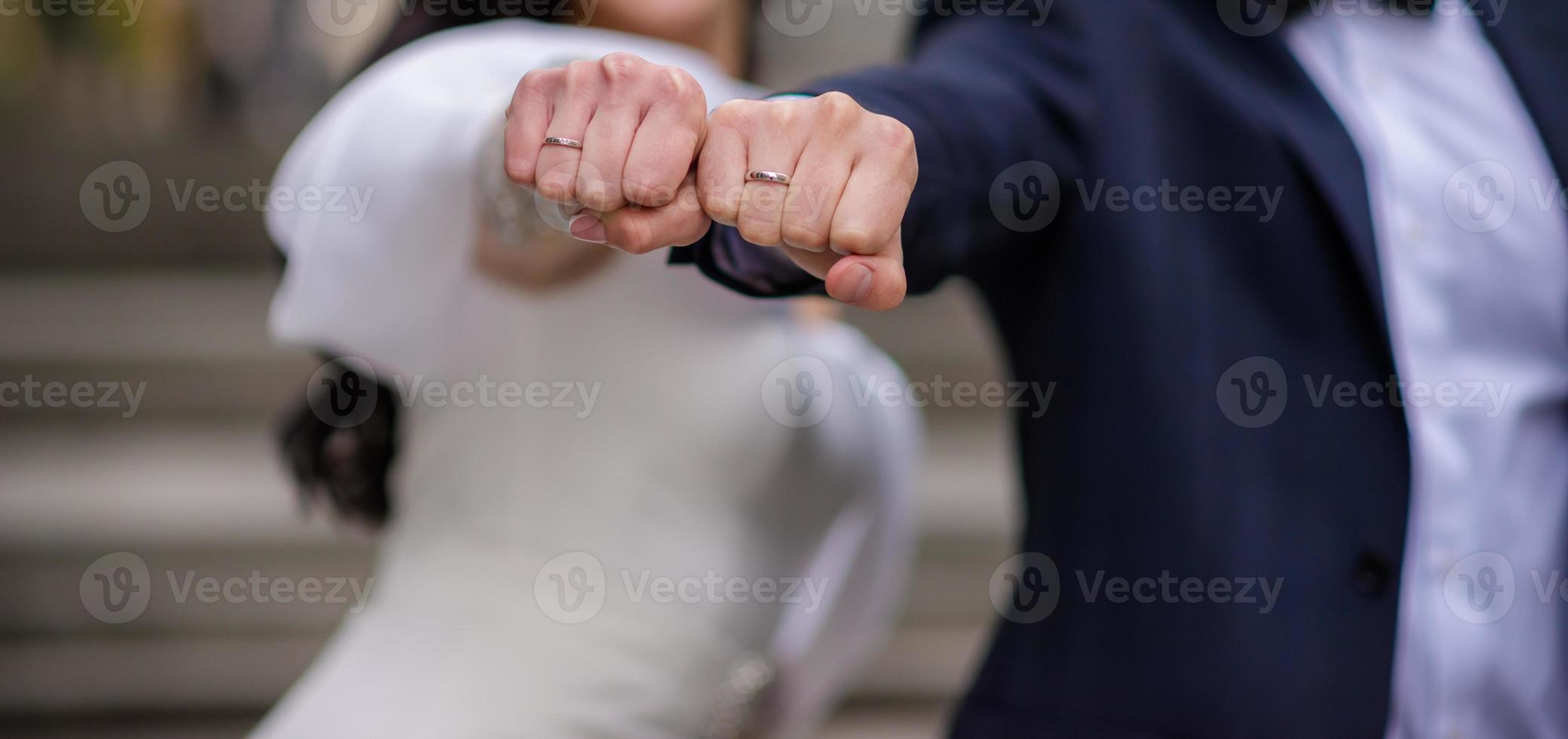 mains de la mariée et du marié avec des anneaux. mariés dans un café. table de bouquet de mariage. la mariée et le marié se tiennent par la main. anneaux de mariage. couple d'amoureux dans un café. thé chaud pour les amoureux photo