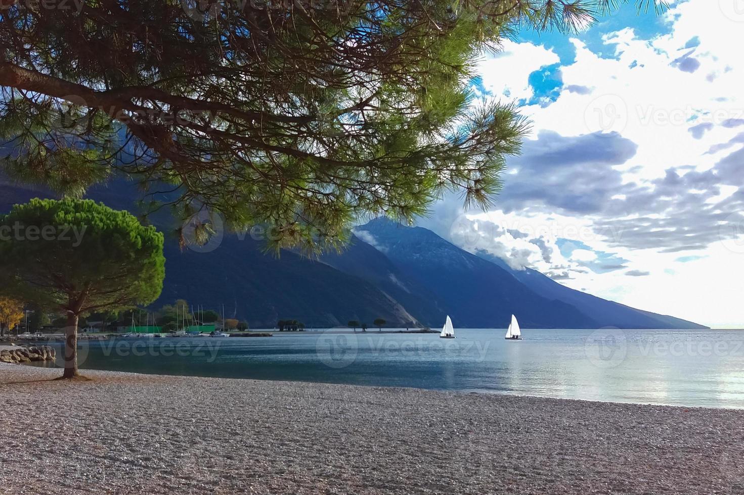 paysage de lac de montagne avec deux yachts à voile, paysage du lac de garde photo