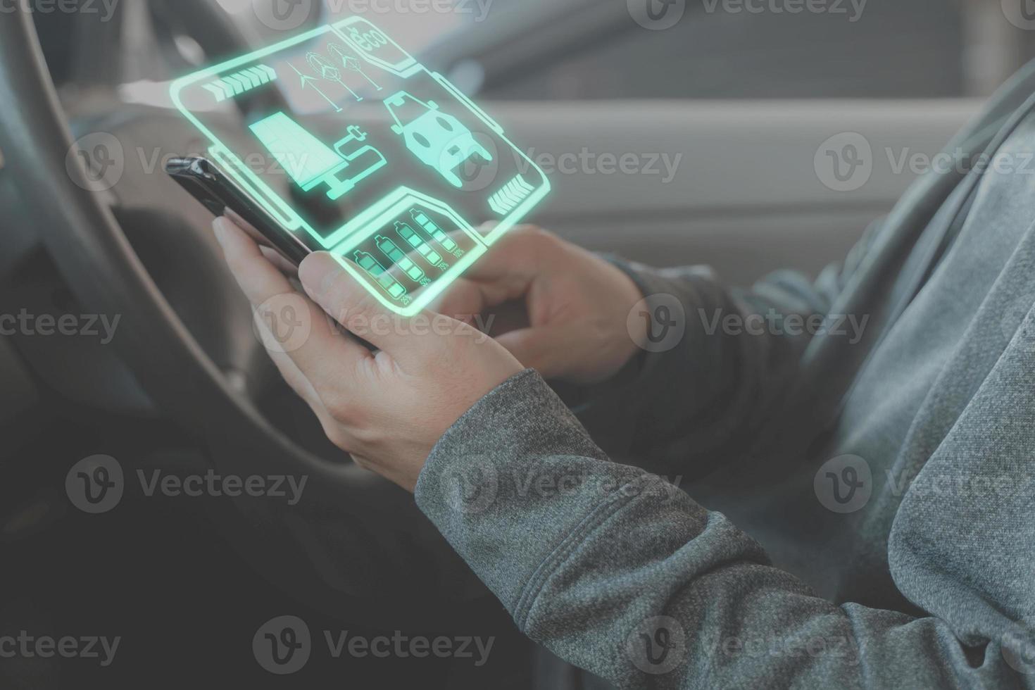 concept d'utilisation de l'énergie propre, main d'homme à l'aide d'un téléphone intelligent dans une voiture écologique à écran virtuel de voiture photo