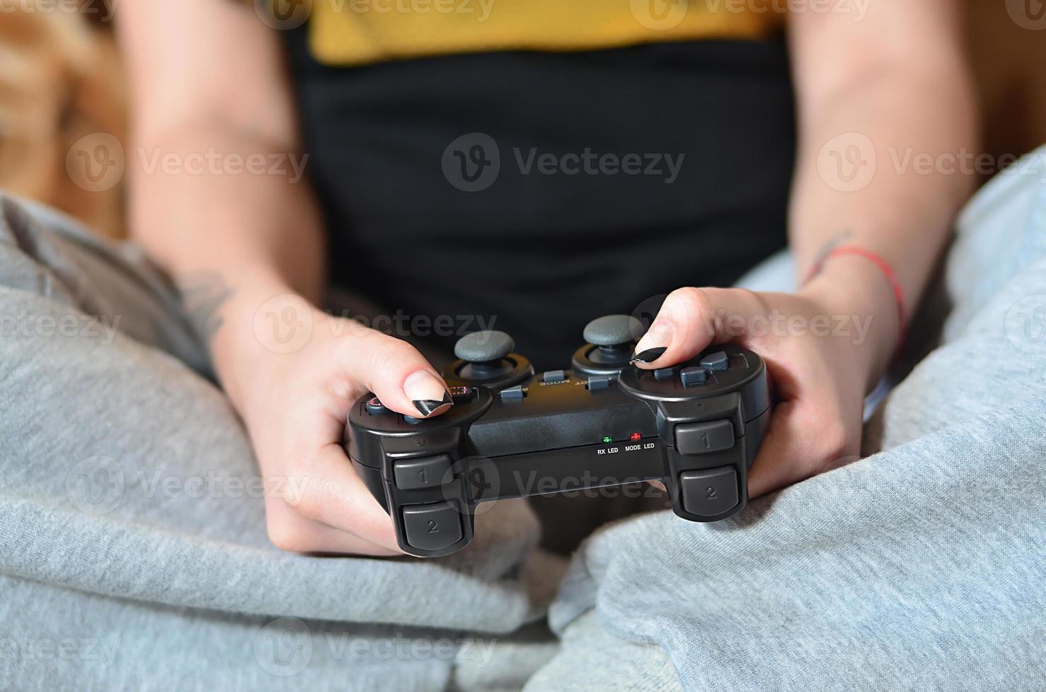 une jeune fille joue à des jeux vidéo avec un joystick noir avec beaucoup de b photo