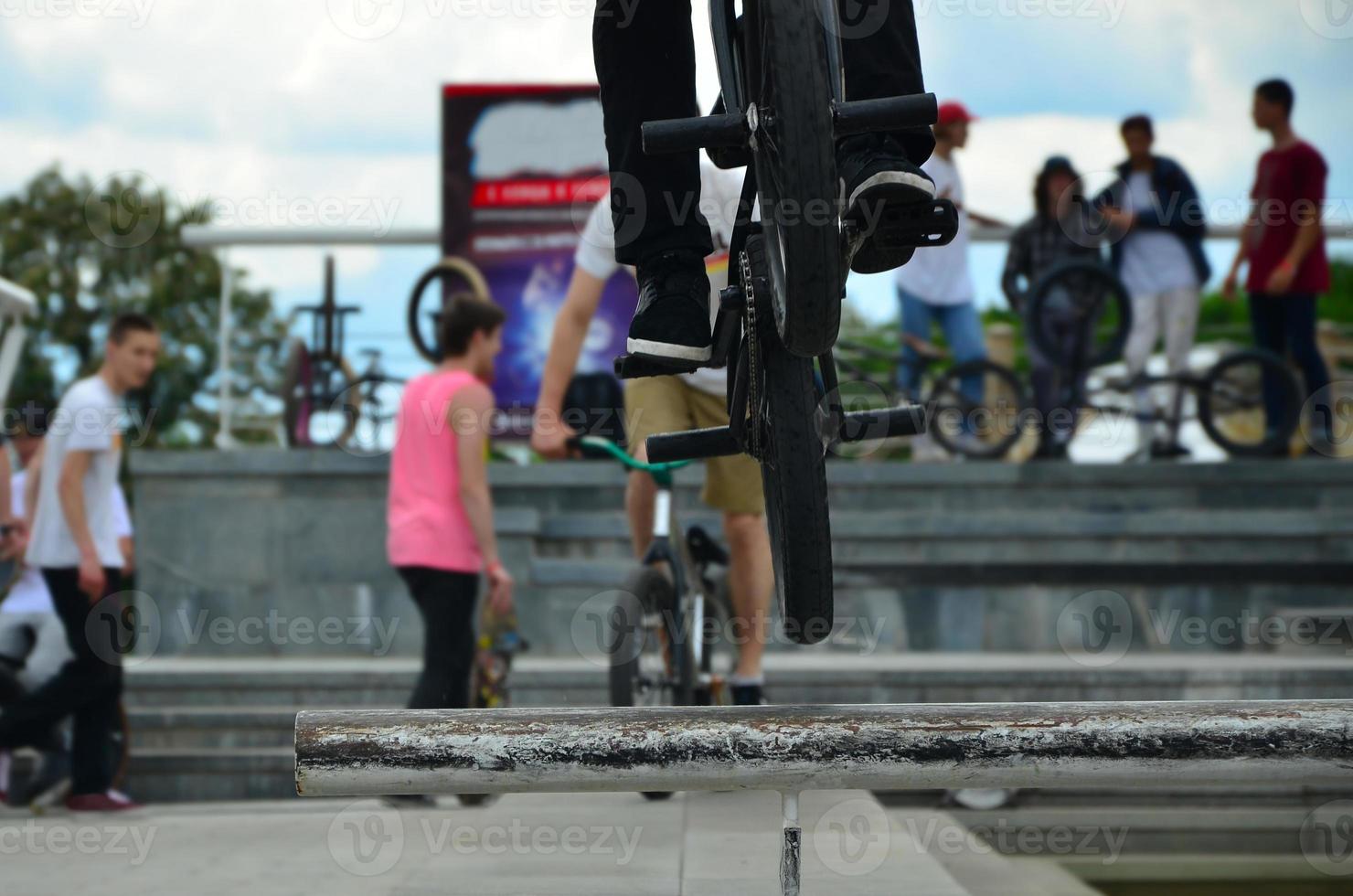 un cycliste saute par-dessus un tuyau sur un vélo bmx. beaucoup de gens avec des vélos en arrière-plan. concept de sports extrêmes photo