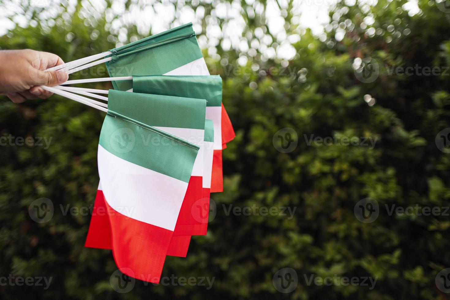 main avec des drapeaux italiens. célébrant le jour de la république d'italie. photo