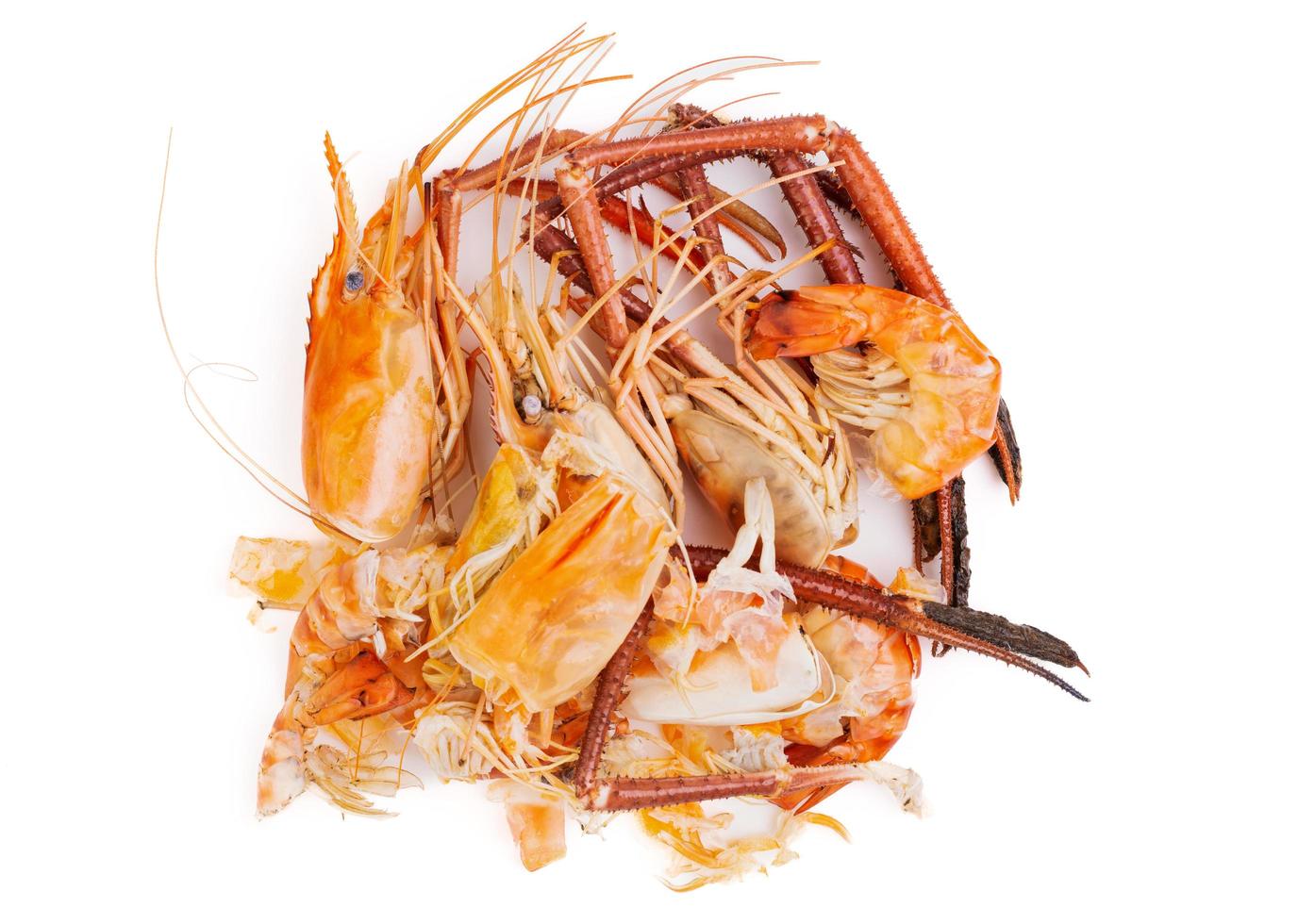 têtes de crevettes et carapaces de crevettes, déchets alimentaires, restes, déchets. fruits de mer naturels. déjeuner. dîner isolé sur fond blanc. photo