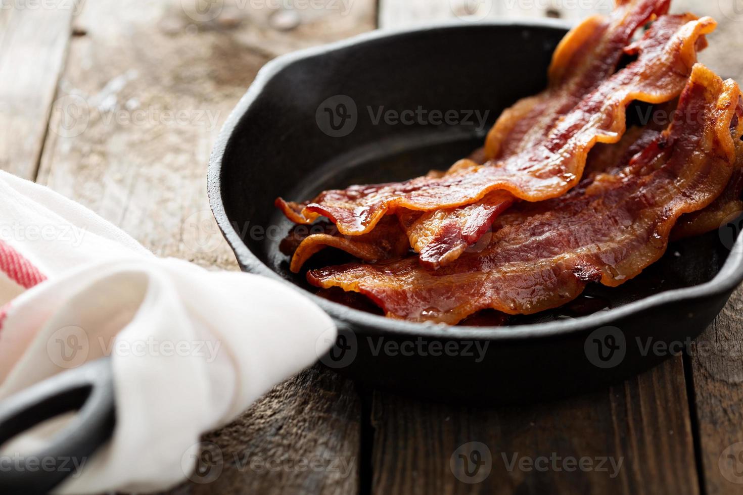 bacon chaud grésillant dans une poêle en fonte photo