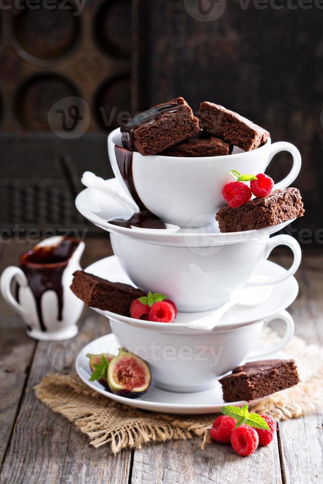 brownies dans des tasses à café empilées avec sauce au chocolat photo