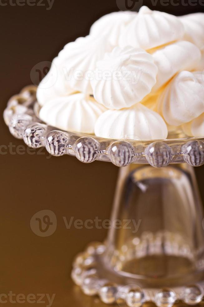 La meringue embrasse les cookies sur un cake stand photo