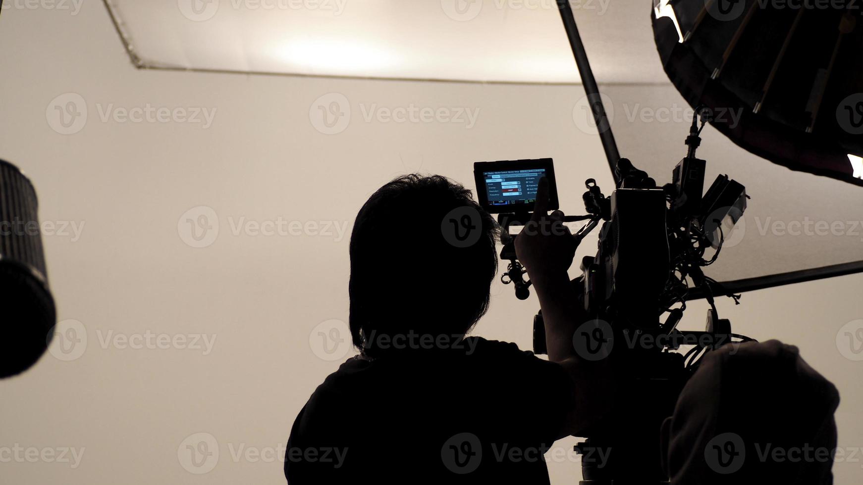 silhouette du photographe vérifiant la caméra vidéo. photo
