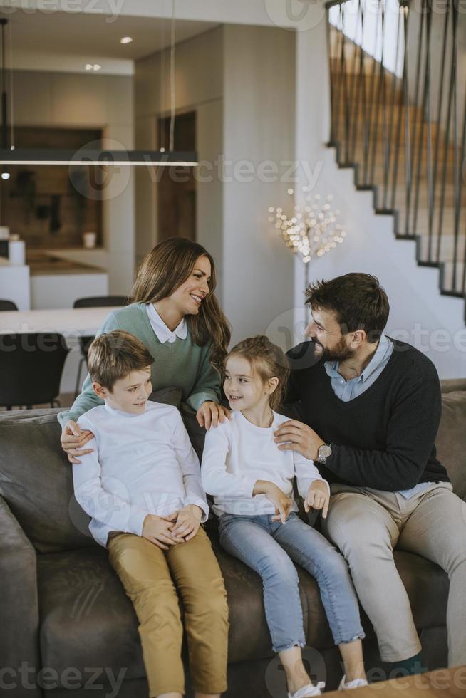 une famille heureuse avec deux enfants passe du temps ensemble sur un canapé dans le salon photo