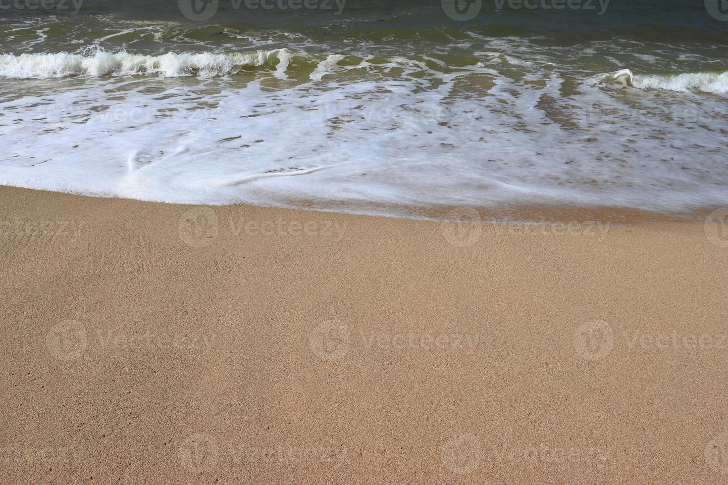 vagues sur le rivage de la belle plage de sable tropicale par une journée ensoleillée photo