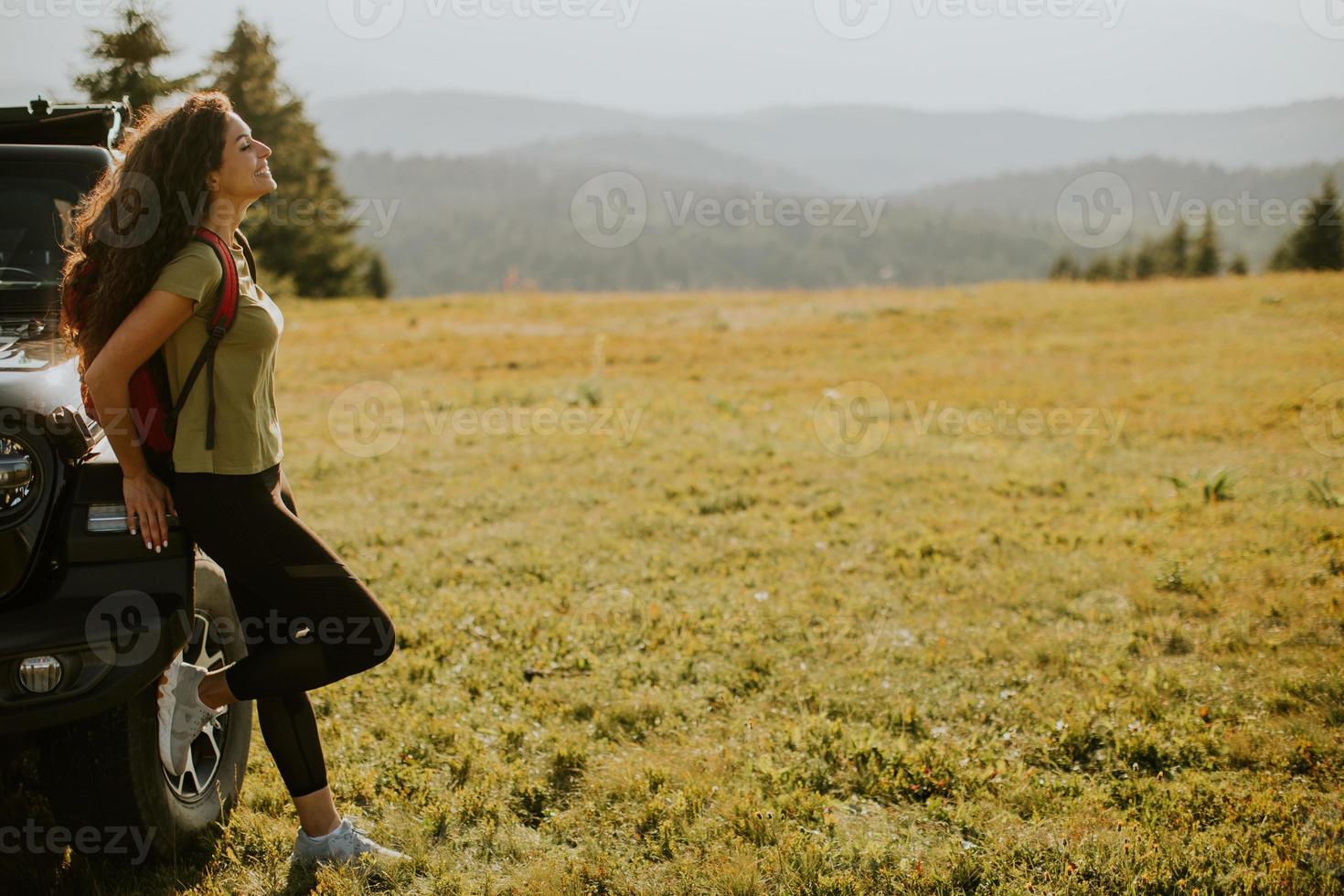 jeune femme se reposant sur un capot de véhicule tout-terrain à la campagne photo