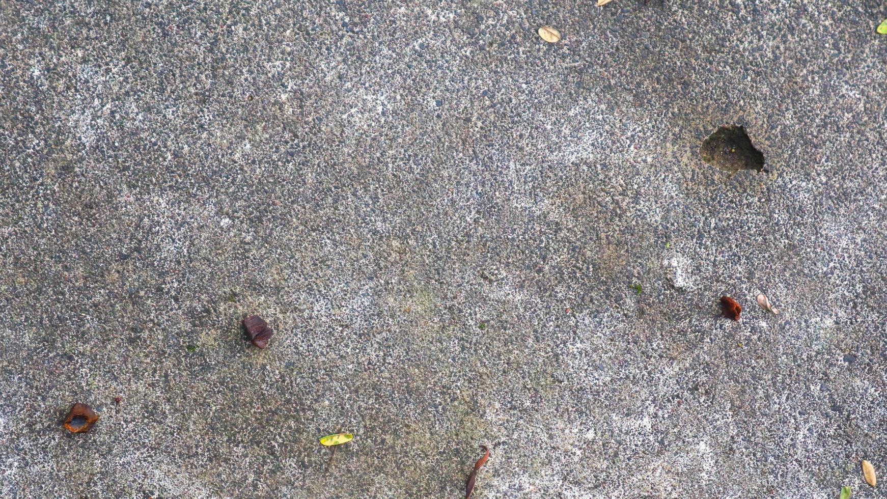 texture de route en béton avec des feuilles qui tombent photo