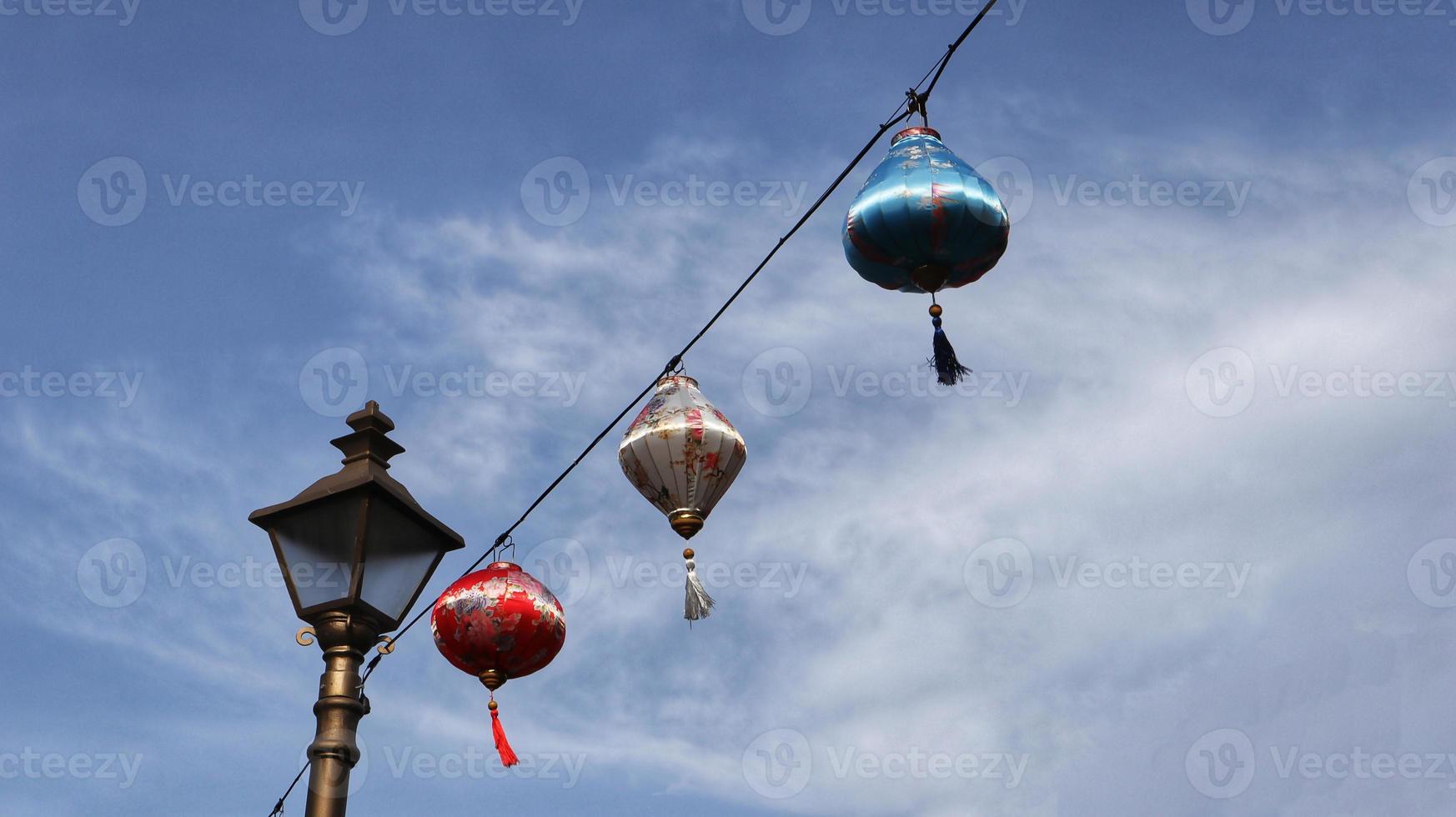 lanterne chinoise colorée à accrocher au câble avec fond de ciel bleu. photo