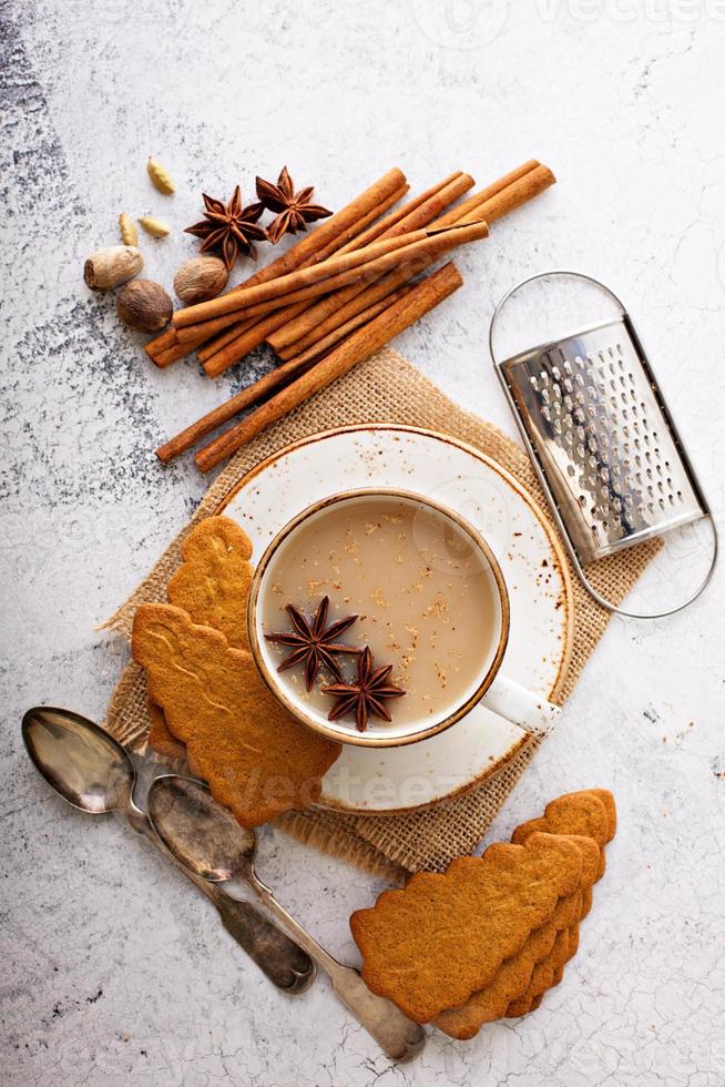 thé masala dans une tasse en céramique avec des épices d'hiver photo