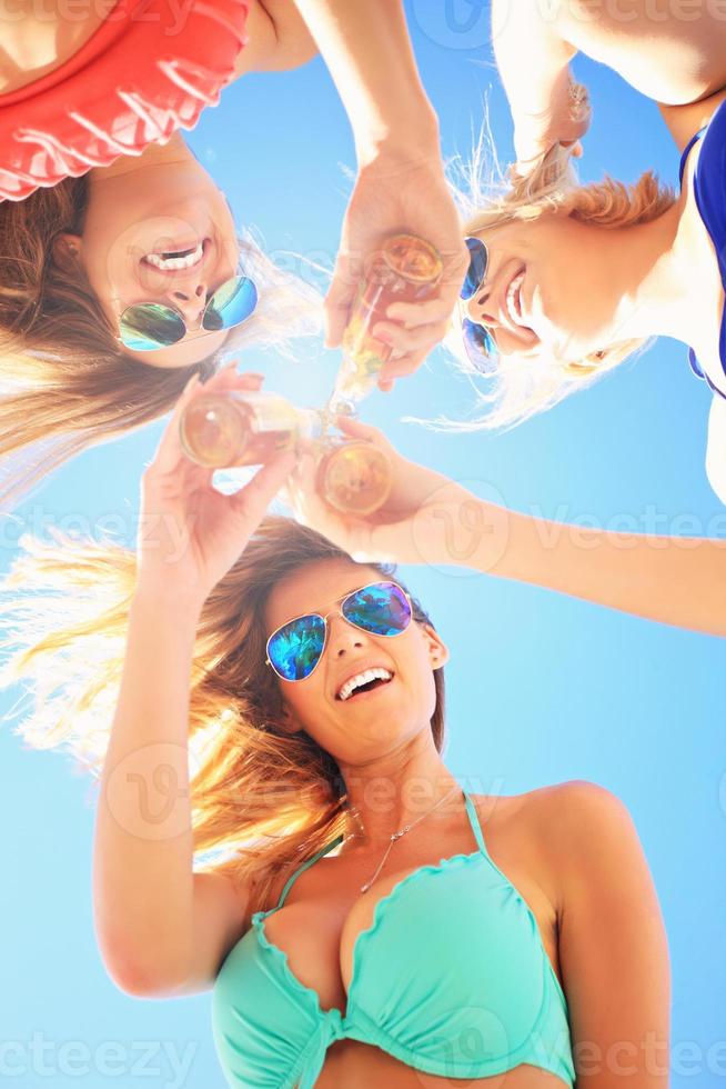 groupe d'amis buvant de la bière sur la plage photo