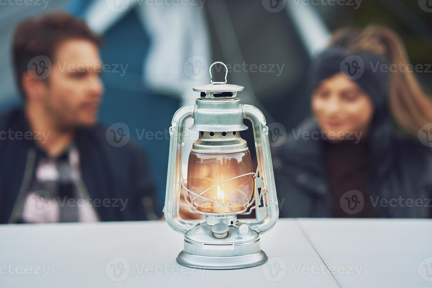 jeune couple sympa s'amusant en camping avec lampe à pétrole photo