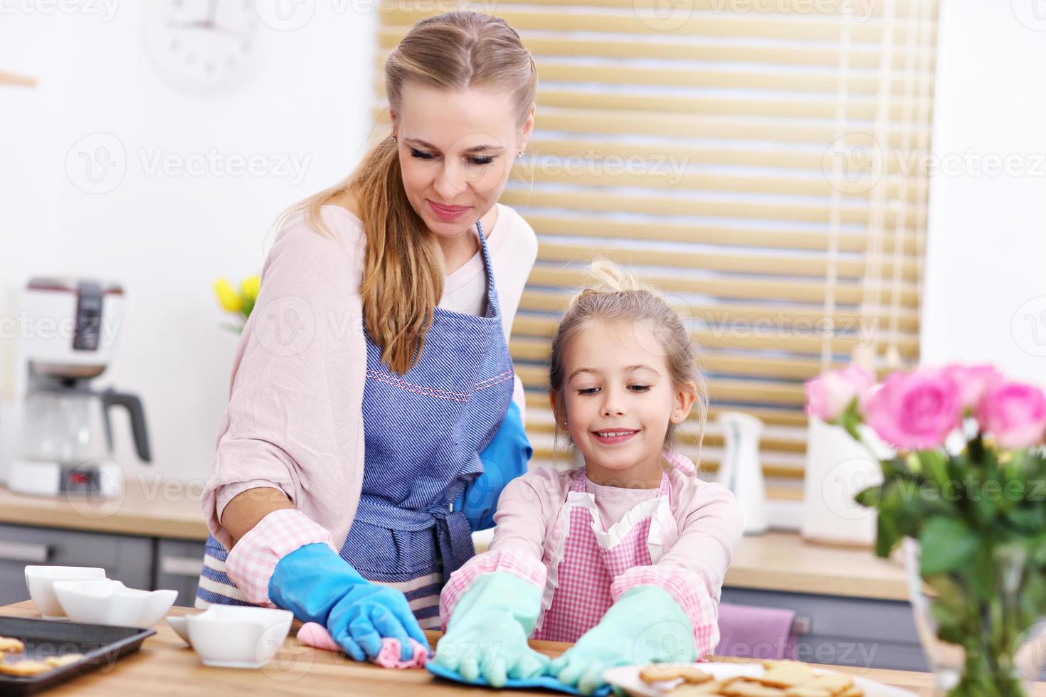 petite fille et sa maman en tabliers nettoyant la cuisine photo