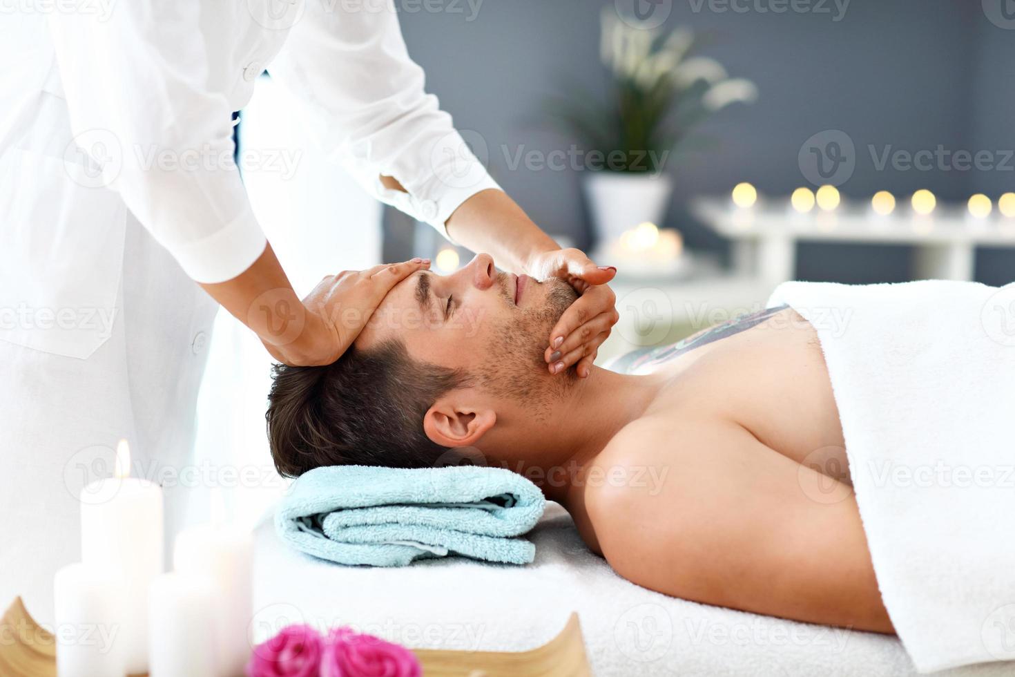 bel homme ayant un massage dans un salon de spa photo