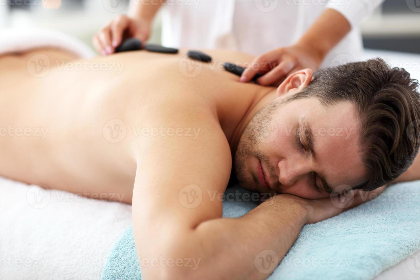 bel homme ayant un massage dans un salon de spa photo