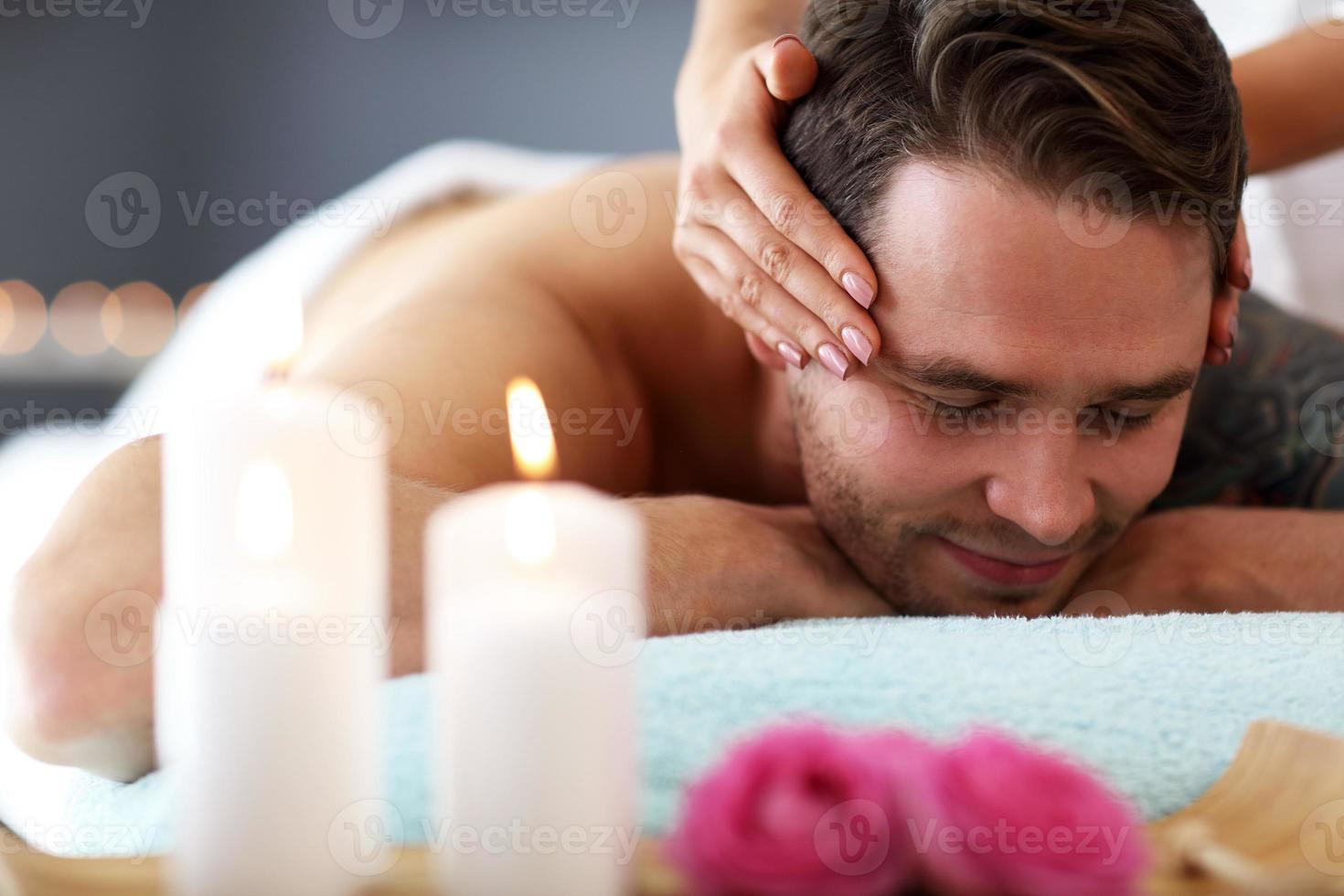 bel homme ayant un massage dans un salon de spa photo