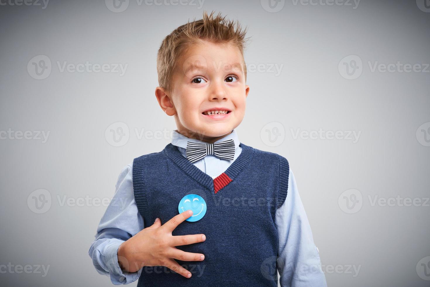 portrait d'un garçon de 4 ans posant sur blanc avec badge photo