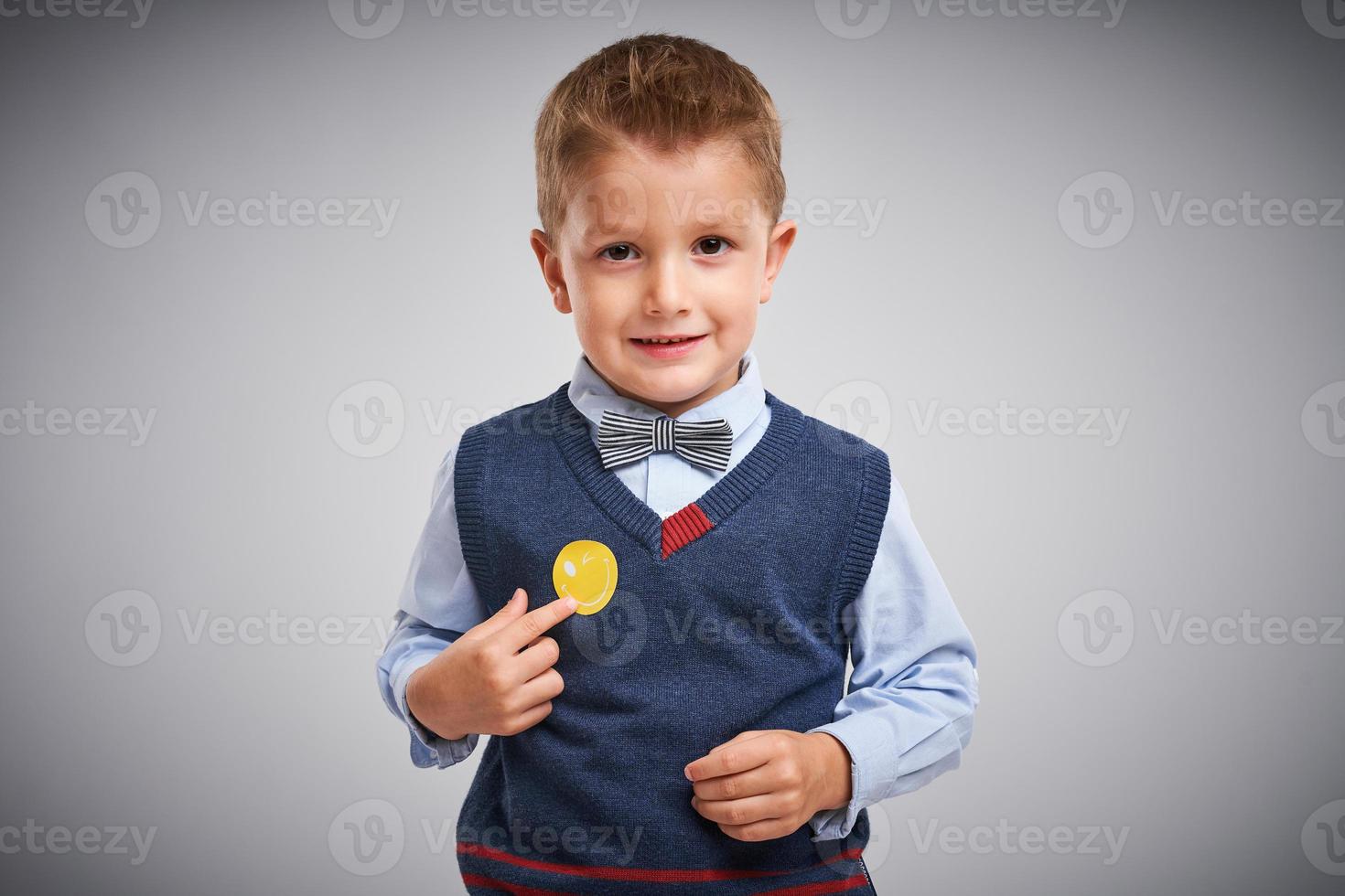 portrait d'un garçon de 4 ans posant sur blanc avec badge photo