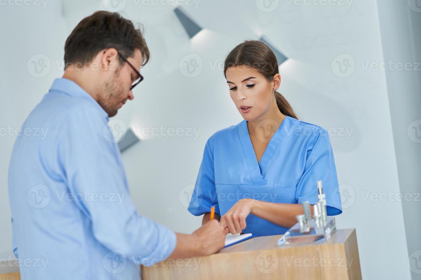 patient signant des documents dans une clinique dentaire photo