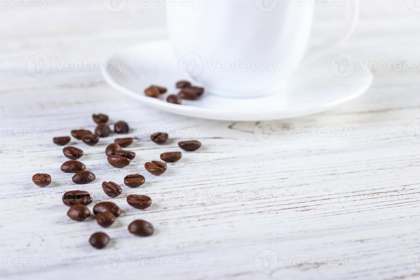 Tasse à café blanche et grains de café sur fond de bois ancien photo