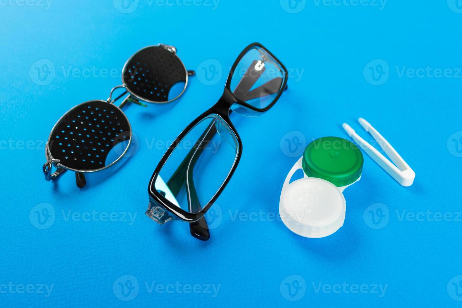 verres sténopés, verres avec récipient et verres pour la vue. notion médicale. un ensemble d'accessoires pour la vue. vue de dessus photo