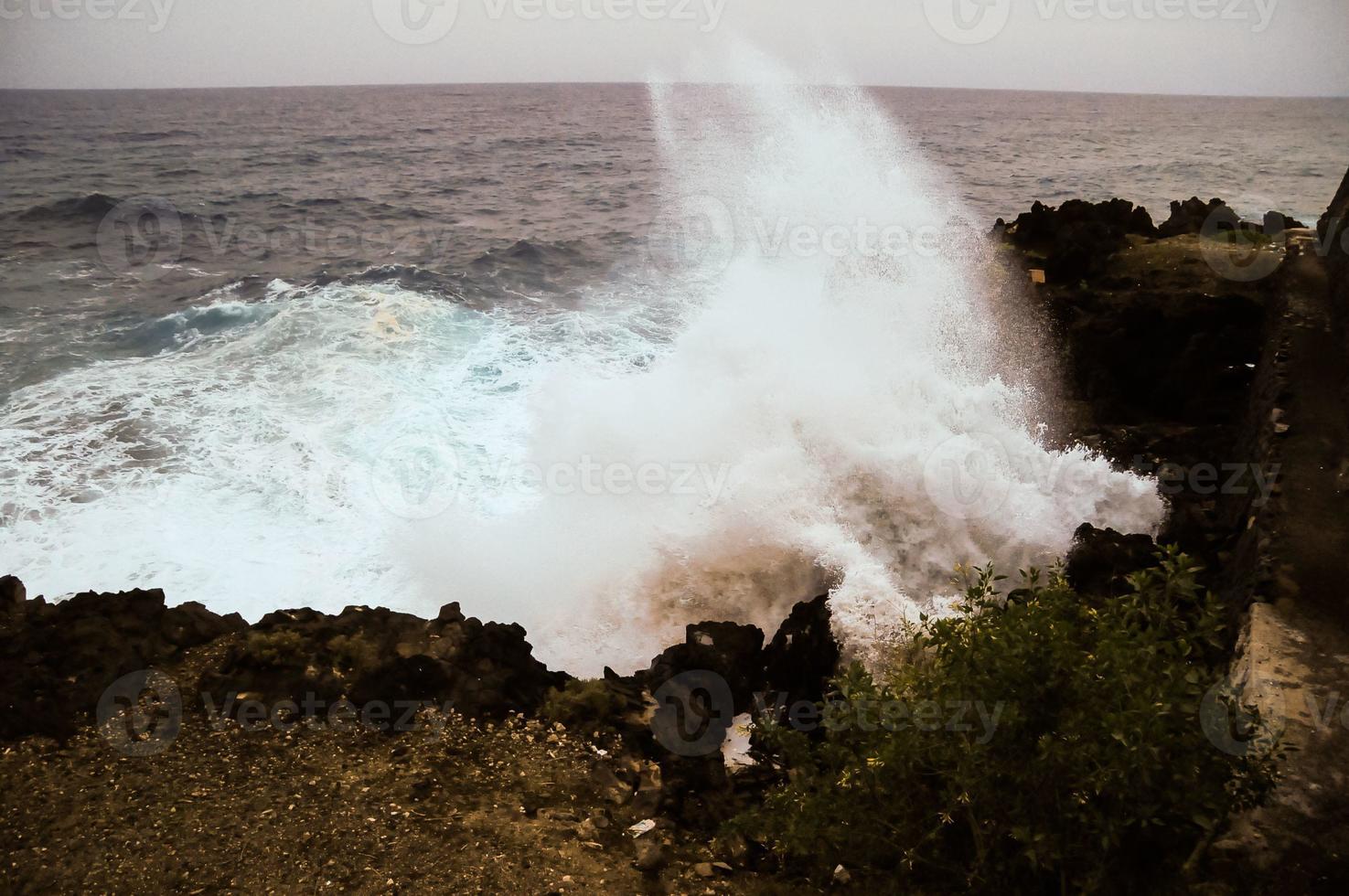 de fortes vagues frappant les rochers photo